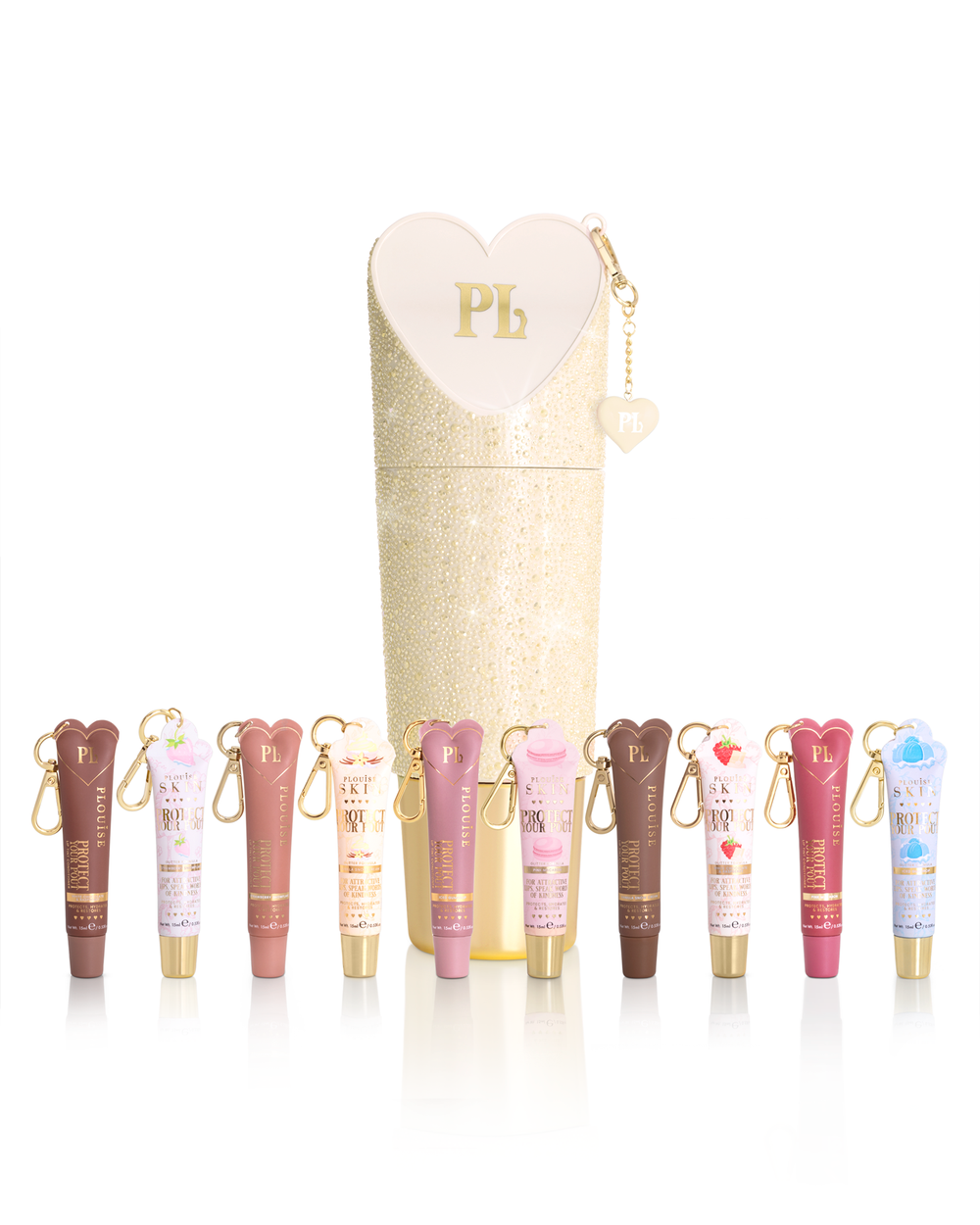 A set of lip conditioner tubes in assorted shades arranged in front of a tall glittery cream-colored cylindrical case with a heart-shaped zipper pull. Each tube has a small gold keychain attached.