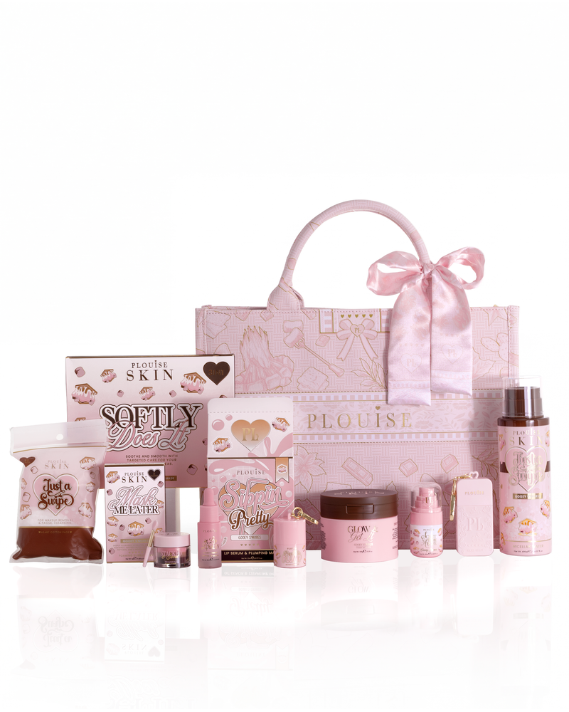 A pink boo basket gift set collection from the brand P.Louise, featuring a large patterned tote bag with a satin bow, surrounded by various pink skincare, lip care and bodycare products in a gooey smore scent and decorated with smores on.
