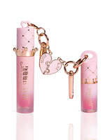 Two pink lip gloss tubes with rose gold keychain accessories, including a crown-shaped cap, heart charms, and a keyring, displayed on a clean white background.