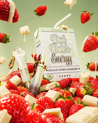 Strawberries, chocolate bars, and 'Bad Bitch Energy' lip duo product on a green background