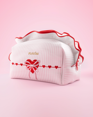 Pink and white striped P.Louise travel skincare and makeup bag with frills and a heart design on it