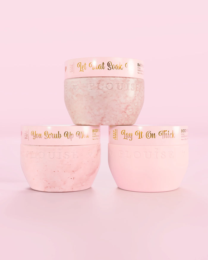 Three P.Louise Hop Into Self-Care Pink Marshmallow pink containers featuring bath salts, body scrub and body butter with gold text on a pink background