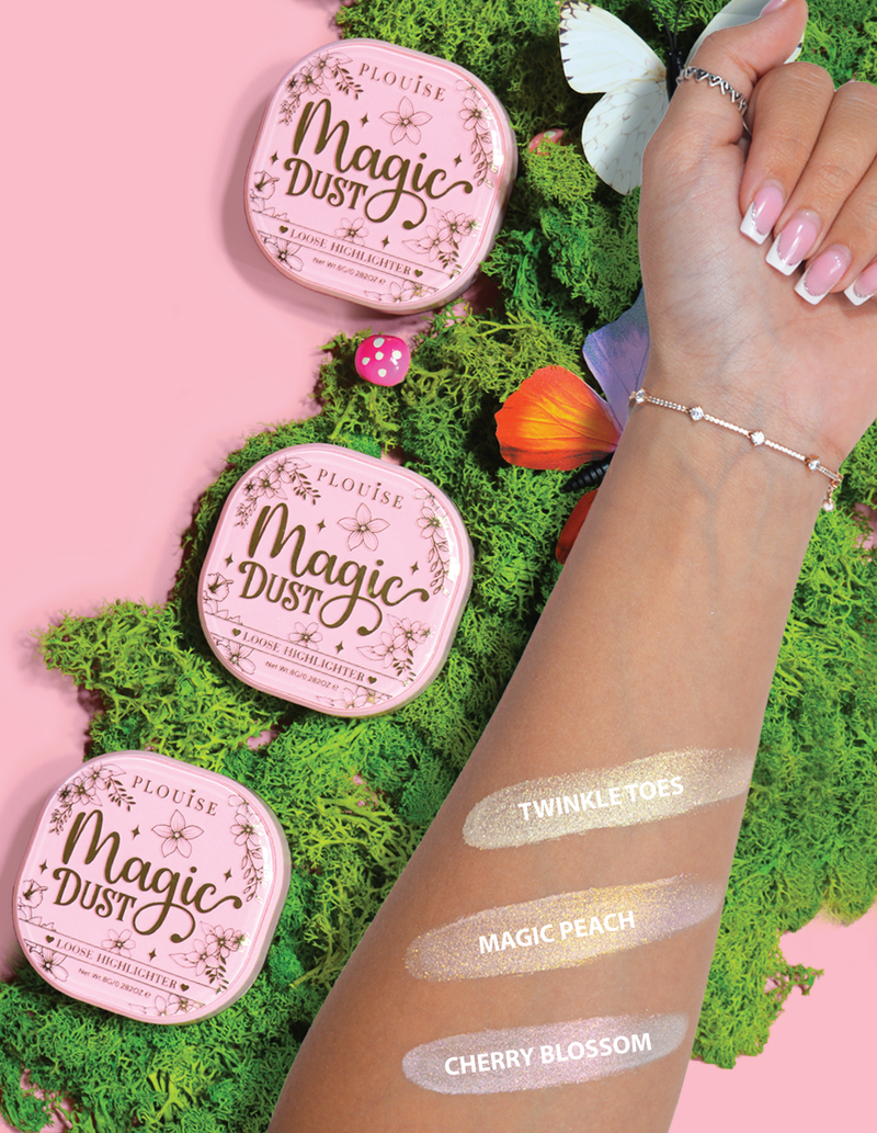 Three pans of P.Louise Magic Dust Loose Highlighter in shades Magic Peach, Cherry Blossom, and Twinkle Toes, with a small amount of highlighter applied to a person's forearm showing the shimmering effect.