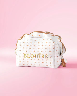 A P.Louise frilled skincare and makeup bag with a small print teddy bear design against a pink background