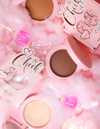 Compacts of the P.Louise The Cheek Of It Baked Powder Bronzer surrounded by candy floss