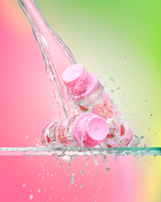 Pink bottles of P.Louise Just A Swipe Micellar Water in watermelon with a colorful splash effect on a gradient background
