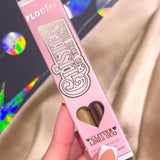 Pink P.Louise Glisten To Your Heart Liquid Glitter Eyeliner Set in Dusk Diva  packaging held by a hand with white nail polish.